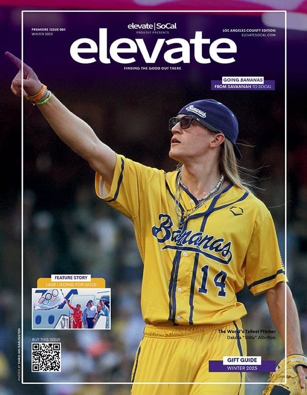 A magazine cover featuring a young man in a yellow baseball uniform with the word 'Bananas' printed on it. He is striking a playful pose with his hand raised. The cover includes the title 'elevate' and mentions a feature story about the Olympics.
